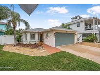 Single-story home with a green garage door and nicely landscaped front yard at 137 Avalon Dr, Ormond Beach, FL 32176