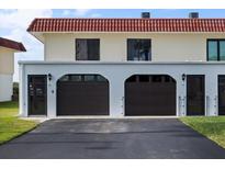 Two-car garage with dark brown doors and a paved driveway at 41 Ocean Palm Villa S # 41, Flagler Beach, FL 32136