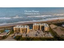 Aerial view of Ocean House condos in Ormond Beach, showing building, pool, and parking at 2222 Ocean Shore Blvd # 102B, Ormond Beach, FL 32176