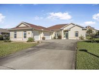 Beautiful one-story home with a three-car garage and lush landscaping at 33 Sea Gull Dr, Ormond Beach, FL 32176