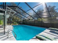 The screened-in pool features a bright blue interior, a ladder, lounge chairs, and access to the house at 5700 E Fort King St, Ocala, FL 34470