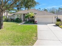 Single-story home with attached garage and manicured lawn at 1221 Harwick Ln, Ormond Beach, FL 32174