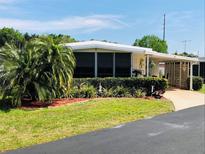 Single-story home with carport and well-manicured landscaping at 215 Rue De Paresse, Tavares, FL 32778