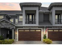 Modern two-story townhome with a dark brown garage door and balcony at 2840 Isles Way, New Smyrna Beach, FL 32168