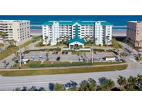 Aerial view of a beachfront condominium building with parking and ocean views at 4641 S Atlantic Ave # 2010, Port Orange, FL 32127