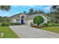Single-story home with blue door, landscaping, and a paved driveway at 1453 Sunningdale Ln, Ormond Beach, FL 32174