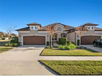 Tan two-story house with brown doors and landscaping at 1510 Kinnard Cir, Ormond Beach, FL 32174