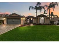 Two-story house with gray garage door and landscaped lawn at 4546 Nottoway Dr, Leesburg, FL 34748