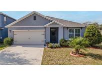 Gray house with a two-car garage and well-manicured lawn at 200 Duke Dr, Deland, FL 32724