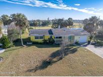 Aerial view of a single-Gathering home on a golf course at 200 Country Club Dr, Ormond Beach, FL 32176