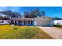 Ranch-style home with attached garage and well-manicured lawn at 2050 Anne Cir, South Daytona, FL 32119