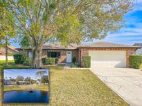 Brick ranch home with attached garage, mature landscaping, and a large tree in the front yard at 840 Chickadee Dr, Port Orange, FL 32127