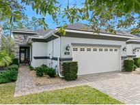 Charming home featuring a 2-car garage, well-maintained landscaping, and a beautiful stone facade at 820 Aldenham Ln, Ormond Beach, FL 32174