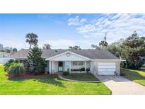 Charming single-story brick home with a well-manicured lawn, mature landscaping and attached garage at 188 Benjamin Dr, Ormond Beach, FL 32176