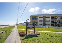 A condo building exterior showcasing a meticulously maintained lawn and clear signage, inviting coastal living at 2100 Ocean Shore Blvd # 1150, Ormond Beach, FL 32176