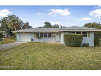 Ranch-style home with a single-car garage and spacious lawn at 55 Neptune Ave, Ormond Beach, FL 32176