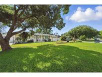 Charming single-story home featuring a lush lawn, mature tree, and a cozy front porch at 1705 Cordova Ave, Daytona Beach, FL 32117