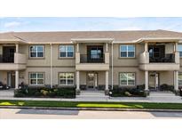 Inviting townhome showcases a neutral facade, covered entryways and well-maintained landscaping at 3411 Gallia St, New Smyrna Beach, FL 32168