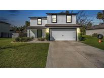 Charming two-story home showcasing a well-maintained lawn and a two car garage at 348 Southern Winds Blvd, Deland, FL 32720