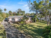 Charming single Gathering home with a front yard surrounded by mature trees and lush landscaping at 445 John Anderson Dr, Ormond Beach, FL 32176