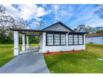 Charming single-story home with a covered front porch, gray driveway, and a lush green lawn at 134 Knight Pl, Daytona Beach, FL 32114