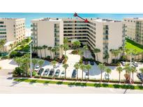 An exterior shot of a condo complex with manicured landscaping, palm trees and a blue ocean in the background at 4555 S Atlantic Ave # 4708, Port Orange, FL 32127