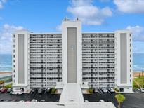 A beachfront condominium building featuring multiple floors with balconies and parking at 1155 Ocean Shore Blvd # 507, Ormond Beach, FL 32176