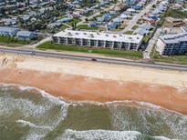 Stunning aerial view of oceanfront condo building with beach access and coastal community at 2600 Ocean Shore Blvd # 103, Ormond Beach, FL 32176