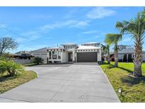 Beautiful exterior showcasing a home with a concrete driveway, landscaping, and a two-car garage at 2244 S Halifax Dr, Daytona Beach, FL 32118