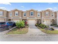 Inviting two-story townhomes featuring neutral paint, attached garages, and beautifully landscaped front yards at 57 Bella Lago Cir, Port Orange, FL 32129