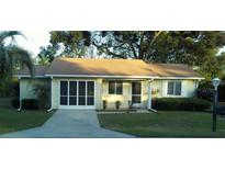 Charming single-story home with a neutral color, well-manicured lawn, and a screened in garage at 10891 Sw 86Th Ave, Ocala, FL 34481