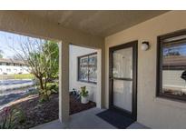 Inviting condo entrance featuring a well-lit doorway, small front garden, and views of the community's pond and landscaping at 1601 Big Tree Rd # 601, South Daytona, FL 32119