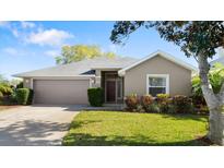 Charming single-story home featuring a well-manicured lawn, a two-car garage and lovely landscaping at 6123 Jasmine Vine Dr, Port Orange, FL 32128