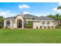 Beautiful single-story home featuring a well-manicured lawn and a welcoming red-door entryway at 3428 Rexford Cir, Ormond Beach, FL 32174