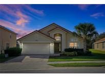 Charming single-story home with a two-car garage, manicured lawn and vibrant landscaping at 410 Viola Dr, Davenport, FL 33837