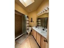 Bright bathroom features a skylight, walk-in shower, and double sink vanity at 105 Cattail Ct, Kissimmee, FL 34743