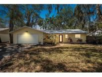 Charming yellow house featuring attached garage and beautiful landscaping at 1432 Mollie Rd, Daytona Beach, FL 32114