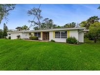 Charming single-story home featuring a well-maintained lawn and bright yellow shutters at 59 Amsden Rd, Ormond Beach, FL 32176
