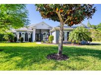 Landscaped front yard showcasing a charming home with black shutters and a well manicured lawn at 1404 Newry Cir, Ormond Beach, FL 32174