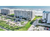 Stunning aerial view of a beachfront condo building with lush landscaping and private beach access at 4631 S Atlantic Ave # 8706, Ponce Inlet, FL 32127