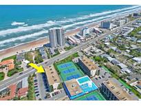Stunning aerial view of the beachfront property with tennis courts and swimming pool and ample parking at 1441 N Atlantic Ave # 417, Daytona Beach, FL 32118