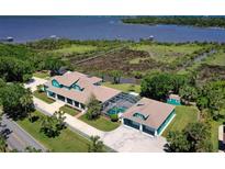 Stunning aerial view of estate home overlooking waterfront with dock and green landscape at 2189 Old Dixie Hwy, Ormond Beach, FL 32174