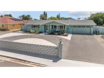 Charming single-story home with a well-manicured lawn, lovely light-blue paint, and a spacious driveway at 324 Plaza Blvd, Daytona Beach, FL 32118