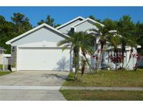 Charming single-story home with a two-car garage, palm trees, and well-maintained landscaping in a residential neighborhood at 8958 Fort Jefferson Blvd, Orlando, FL 32822