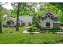 Charming home featuring a lush green lawn, mature trees, and unique architectural details at 530 Estates Pl, Longwood, FL 32779