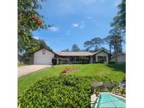Charming single-story home with well-manicured lawn and an inviting, covered porch with a screened in pool in the bottom corner at 75 Knollwood Estates Dr, Ormond Beach, FL 32174