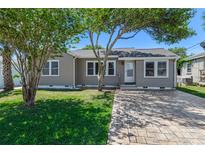 Charming single-story home featuring a well-maintained lawn and inviting curb appeal with mature trees at 394 Golf Blvd, Daytona Beach, FL 32118