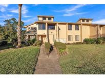 Inviting townhome with a well-manicured lawn and trimmed bushes lining the walkway at 133 Blue Heron Dr # C, Daytona Beach, FL 32119