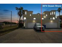 Inviting Mediterranean-style home with a spacious driveway and two-car garage at dusk at 3074 Ocean Shore Blvd, Ormond Beach, FL 32176