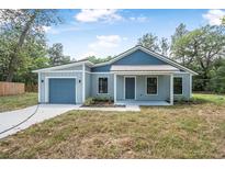 Charming single-story home featuring a front-facing garage and covered porch at 5620 Ridgewood Ave, De Leon Springs, FL 32130
